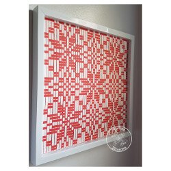 Red and white woven paper snowflake design in white hanging frame by rolling blossoms angled view